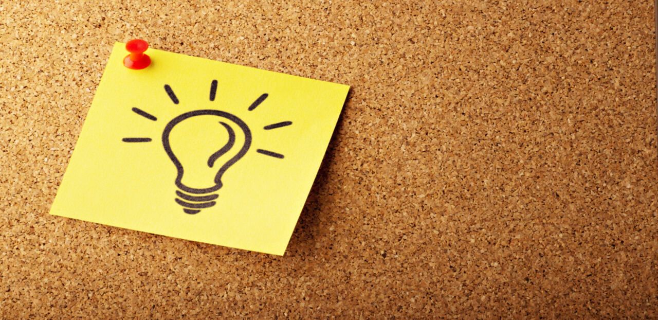 A light bulb-shaped icon on a yellow sticky note