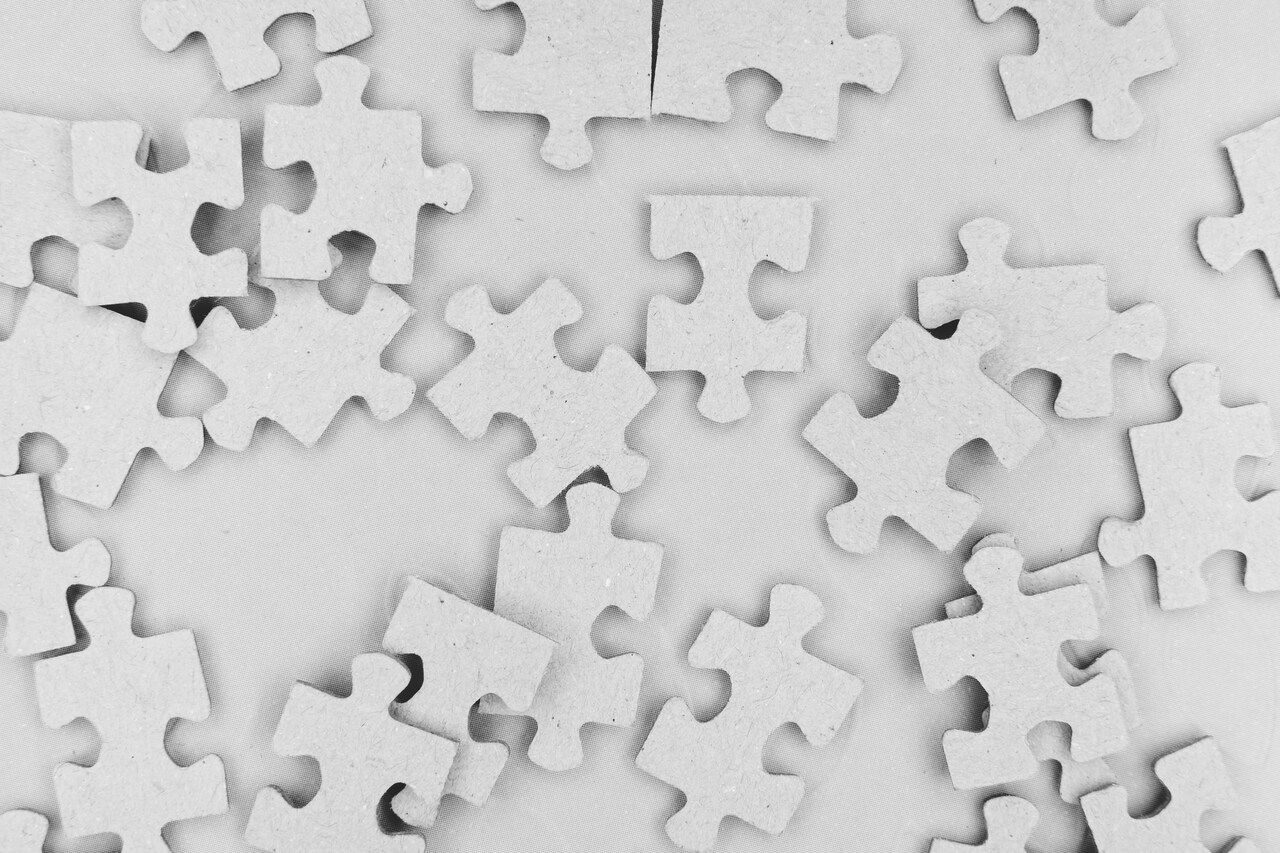white jigsaw puzzle pieces on a white floor