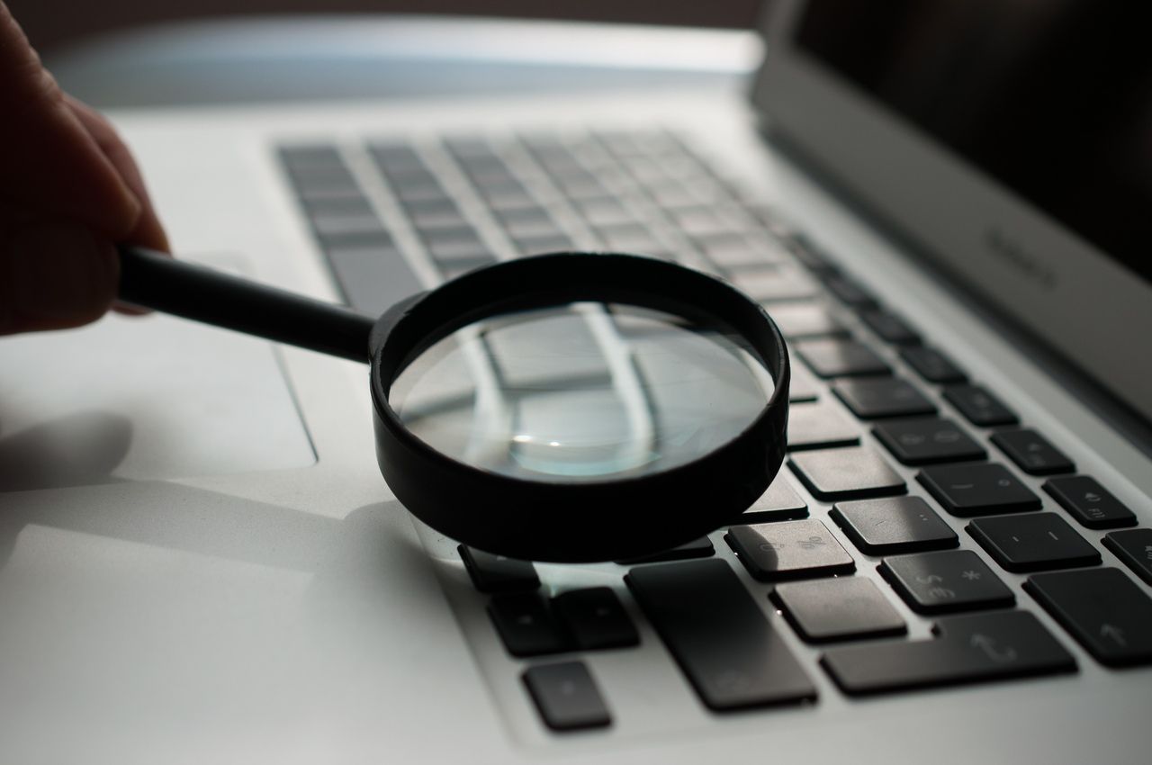 magnifying glass staying on the laptop keyboard