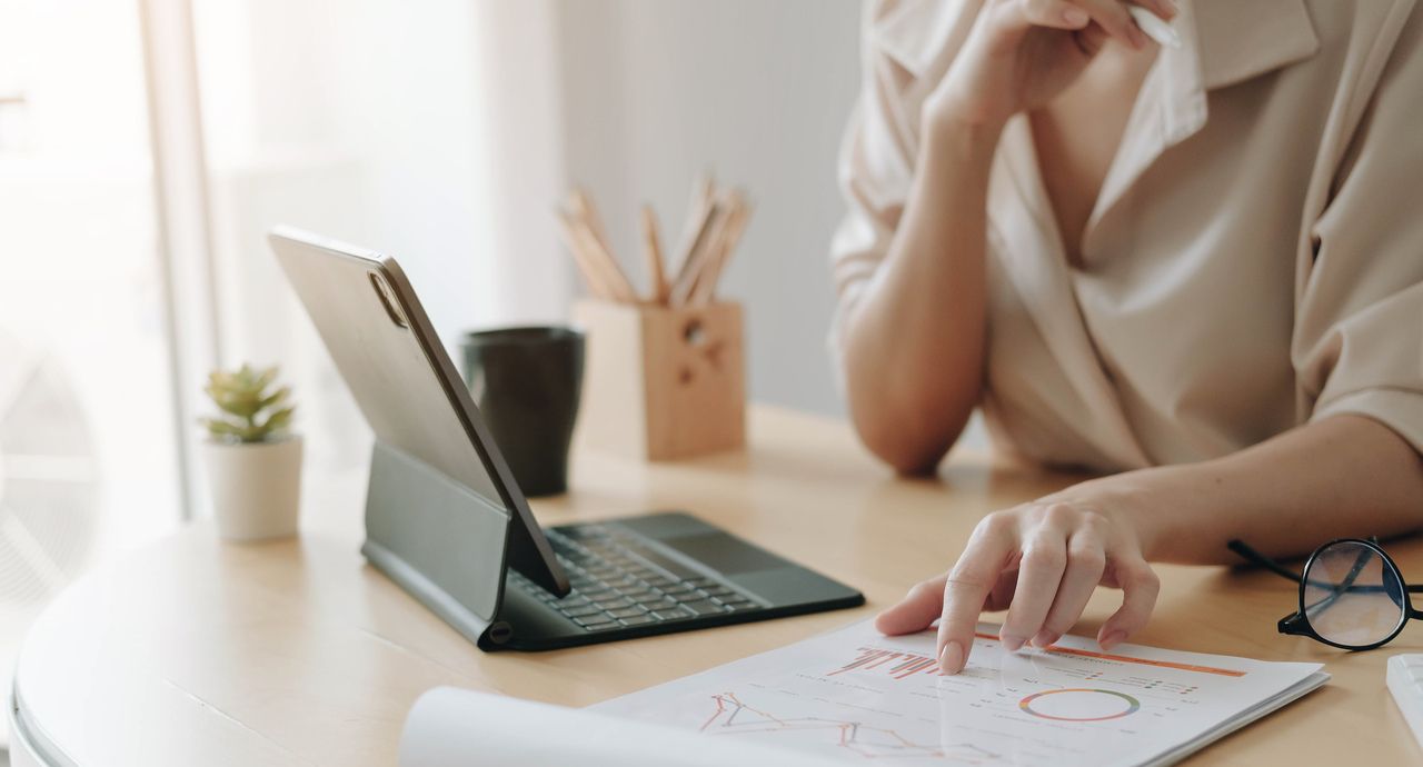 a person working on her tablet at a desk, checking analysis