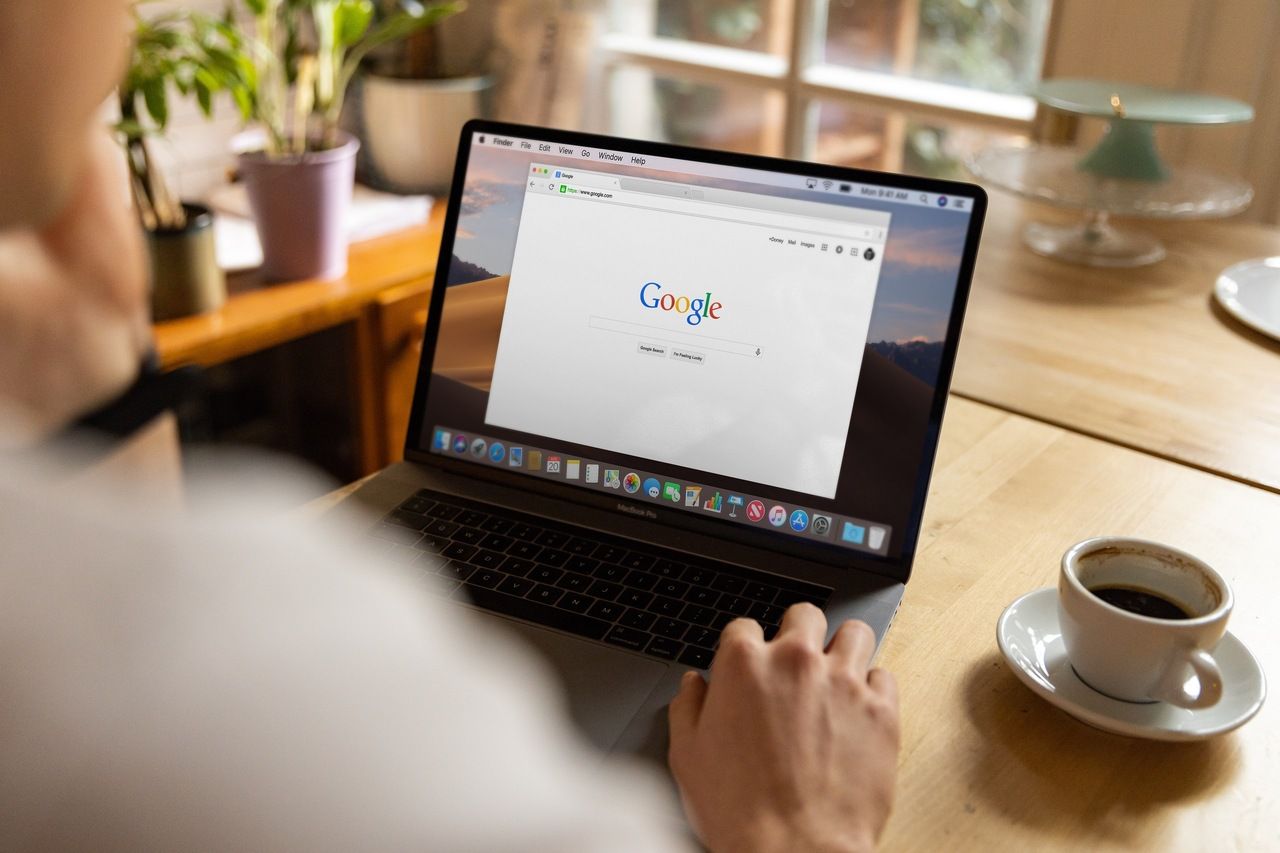 a person searching on Google with laptop and drink coffee