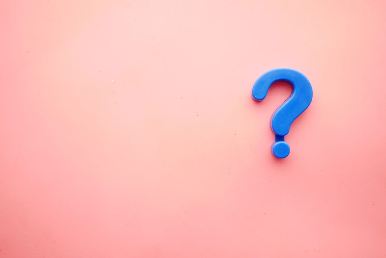 a blue question mark on pink background