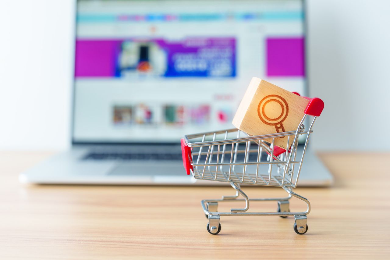 shopping cart with magnifying icon block and laptop